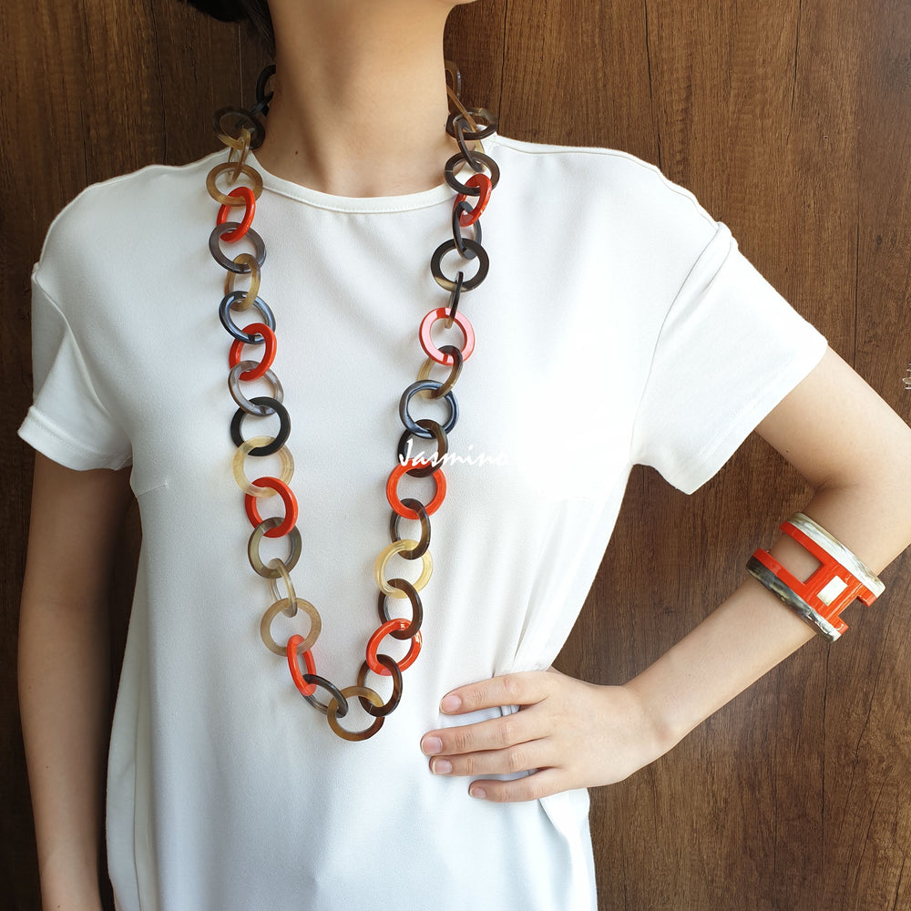 
                  
                    A model is wearing Jasmino unique handmade Bohemian chain link necklace featured brown and orange in natural buffalo horn for women's gifts
                  
                