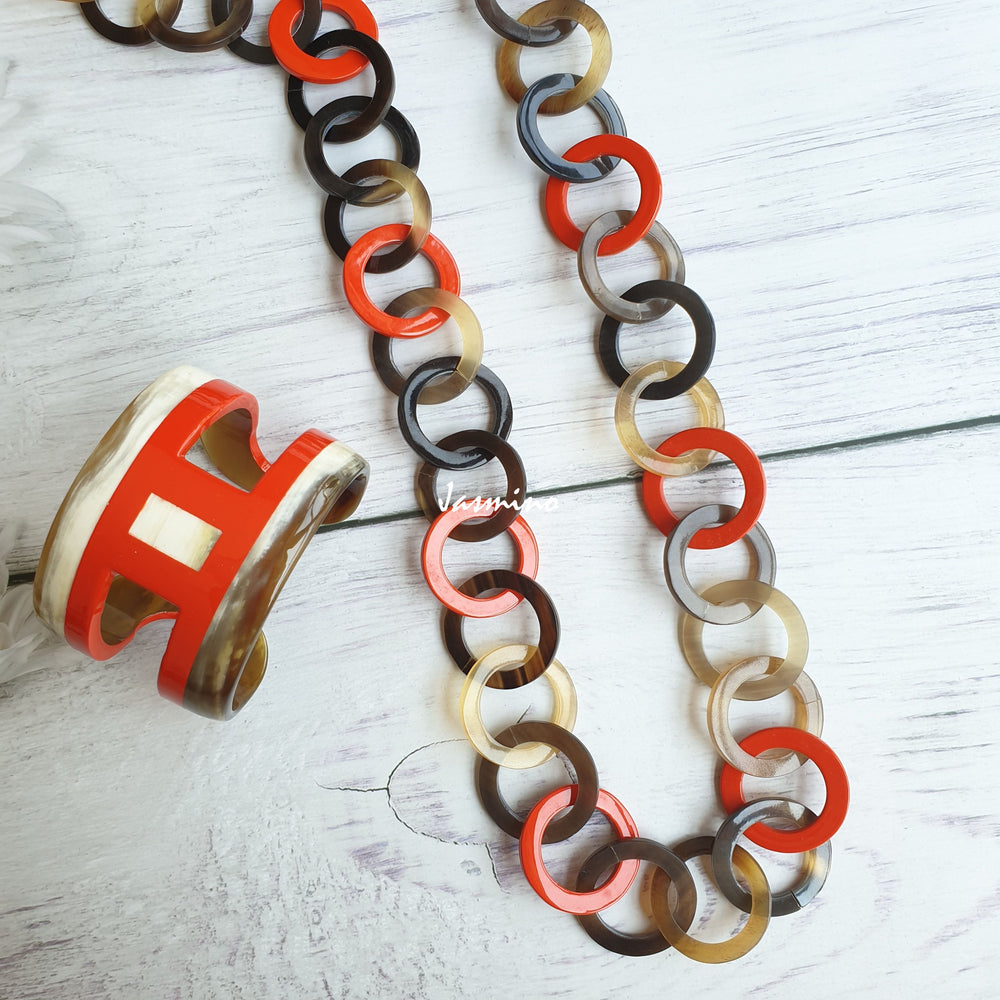 
                  
                    A set of Jasmino unique handmade Vintage chain link necklace and H-shaped cuff bracelet featured orange and white in natural buffalo horn for women's gifts on Thanksgiving
                  
                