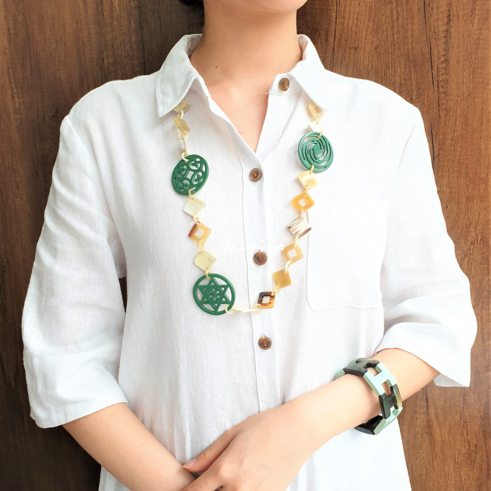 
                  
                    A model is wearing unique handmade Christmas chain link necklace and bangle bracelet featured green and white in natural buffalo horn 
                  
                