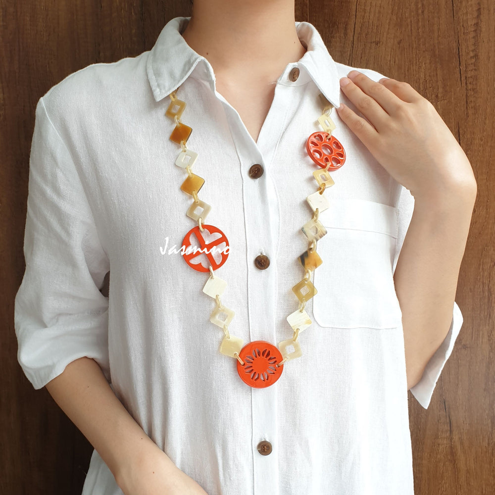 
                  
                    A model is wearing unique handmade necklace featured some large orange pieces with different patterns on the light background, unique gift for your friend
                  
                