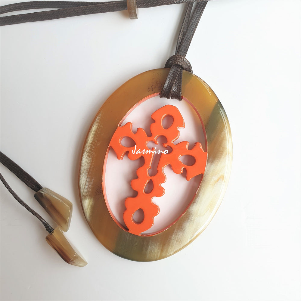 
                  
                    Jasmino unique handmade cross oval pendant in natural buffalo horn and orange for men and women
                  
                