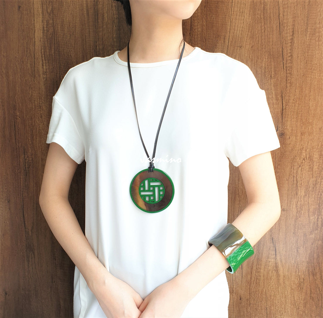A model is wearing Vintage unique pendant features brown and green made of natural buffalo horn