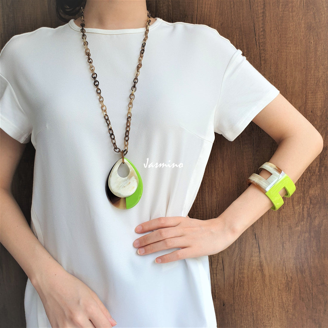 A women is wearing handmade Vintage double teardrop pendant features a green and white colour made of natural buffalo horn