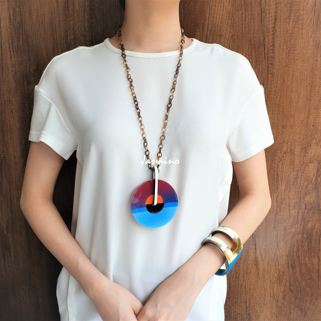 A model is wearing unique handmade rainbow pendant features a turquoise and purple colour made of natural buffalo horn