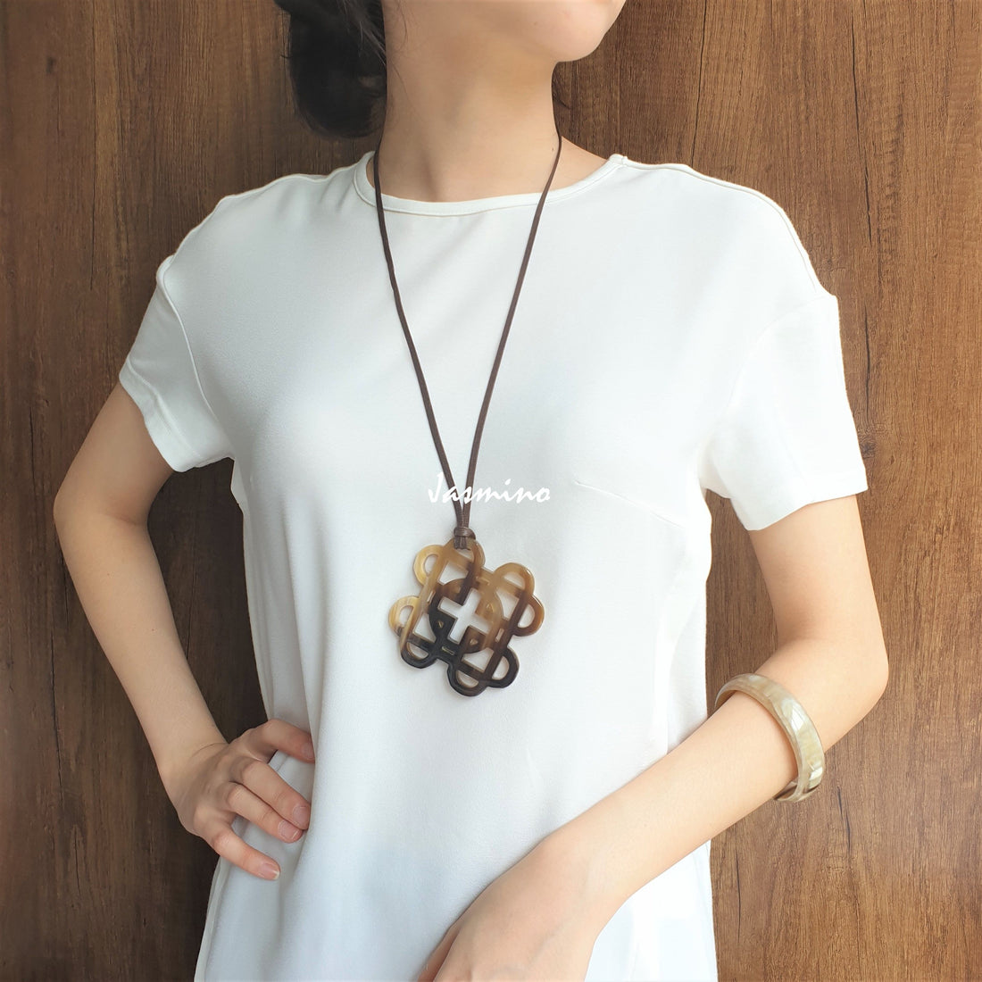 A model is wearing Vintage unique knot square pendant features a brown colour made of natural buffalo horn