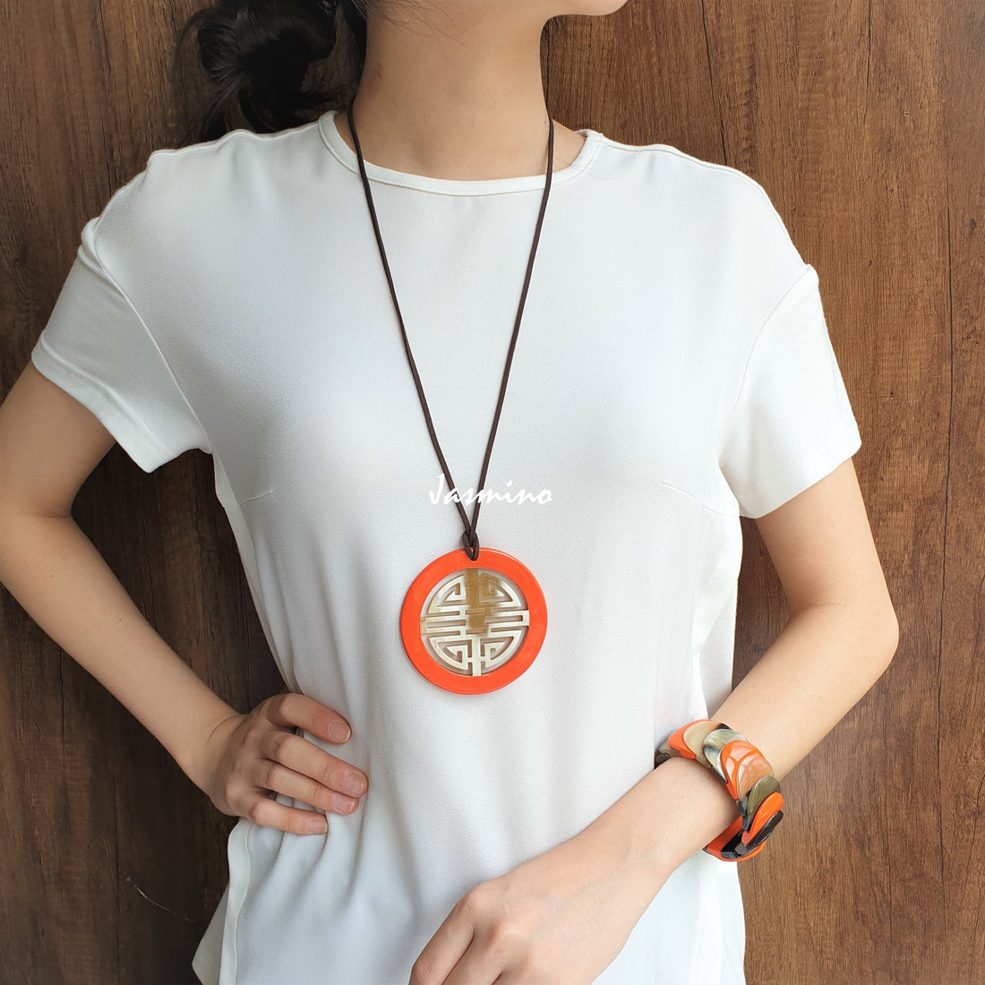 A model is wearing Vintage Asian circle pendant features a circle shape and pink colour that is made of natural buffalo horn