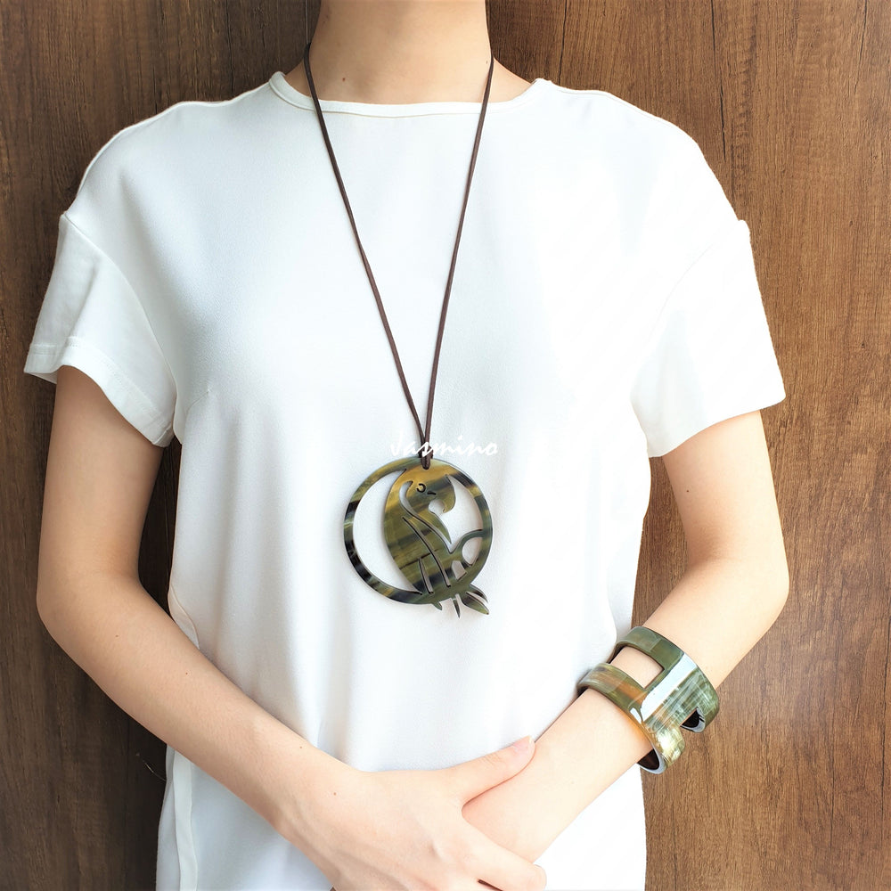 
                  
                    A model is wearing unique Vintage pendant is shaped by a bird - Phoenix, made of natural buffalo horn
                  
                