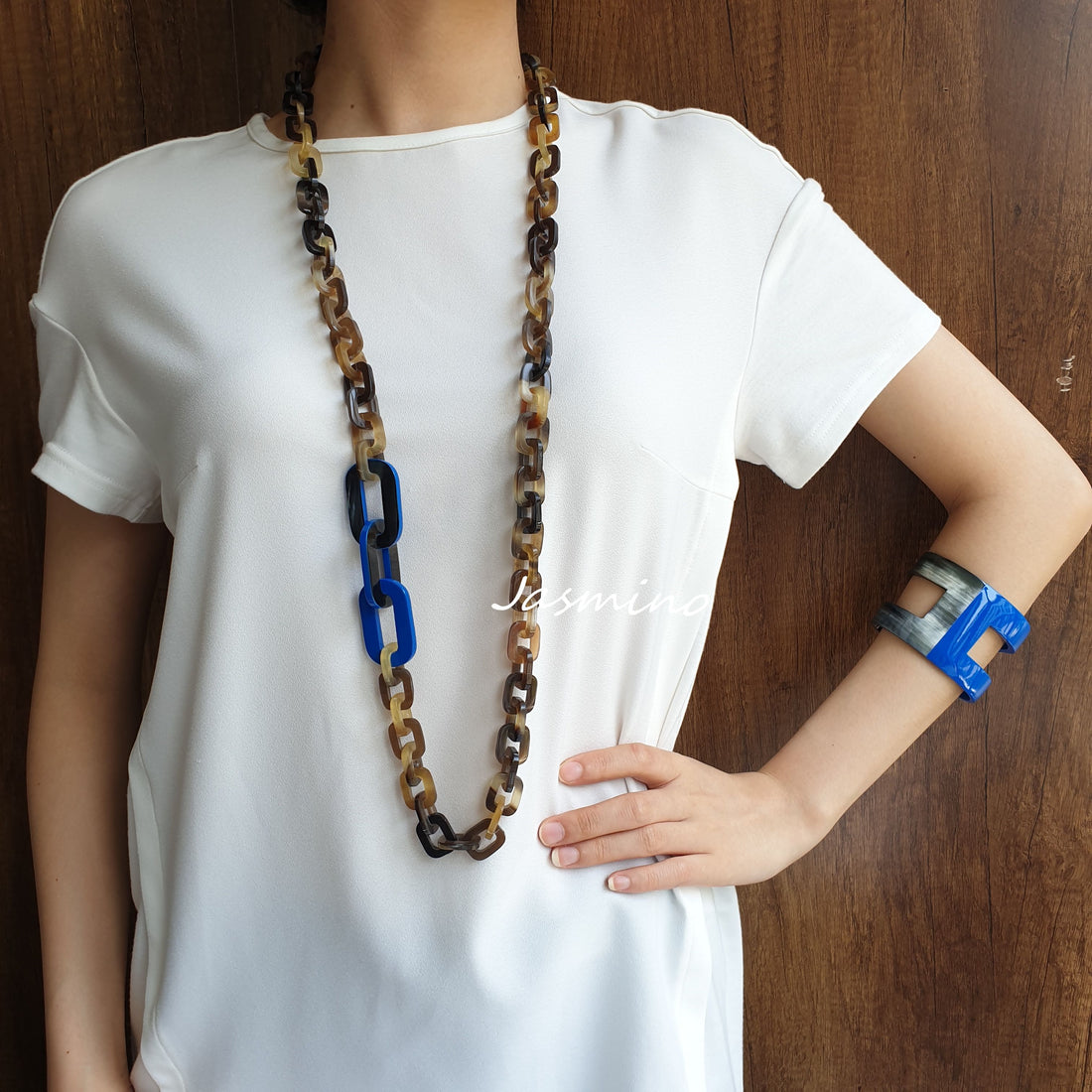 A model is wearing a set of unique handmade Vintage rectangle chain necklace and H-shaped cuff bracelet in natural buffalo horn for women