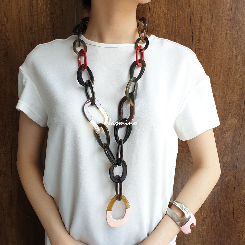 
                  
                    A model is wearing a set of unique handmade Bohemian Vintage chain necklace and cuff bracelet in natural buffalo horn for women
                  
                