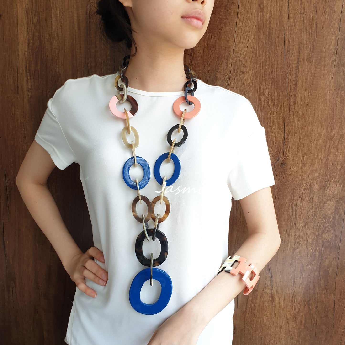 A model is wearing a set of Jasmino unique handmade wide chain necklace and H-shaped cuff bracelet in natural buffalo horn for women