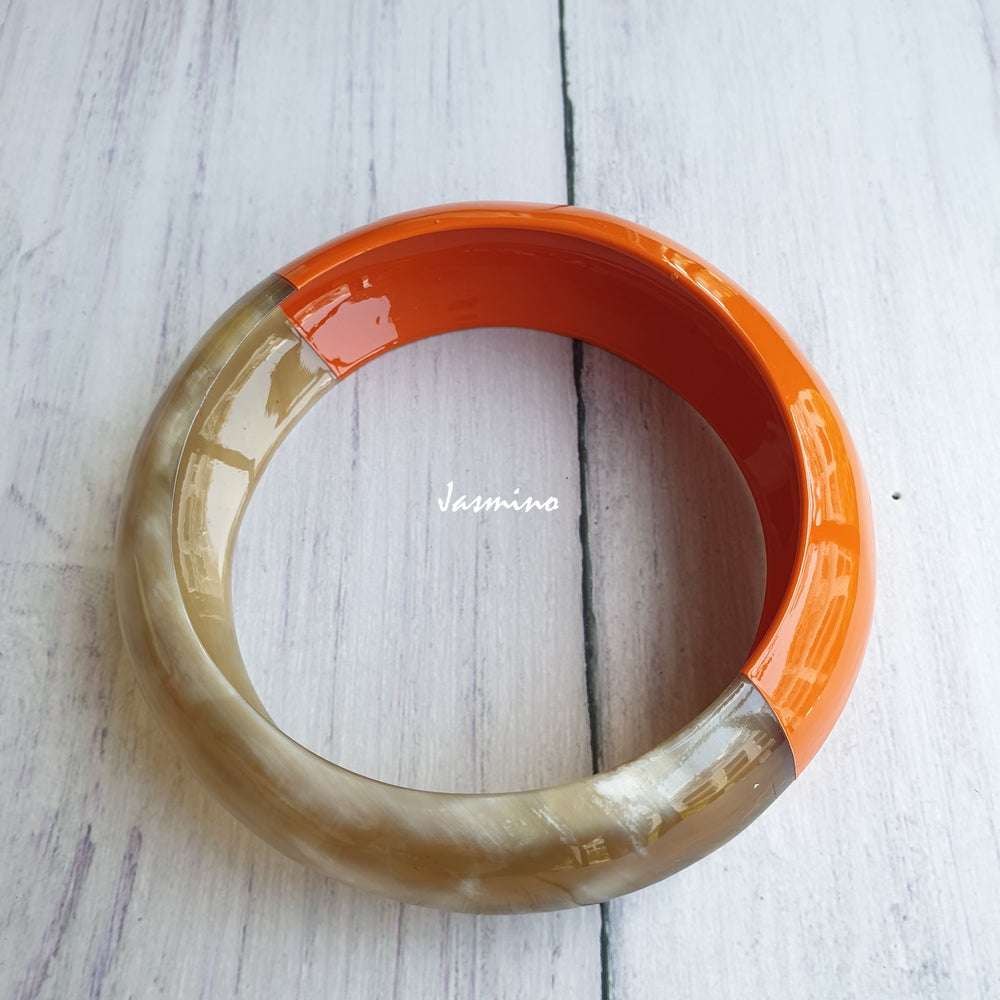 
                  
                    Jasmino unique handmade bangle bracelet is detailed by an orange half and a white half in natural buffalo horn for Christmas gifts
                  
                