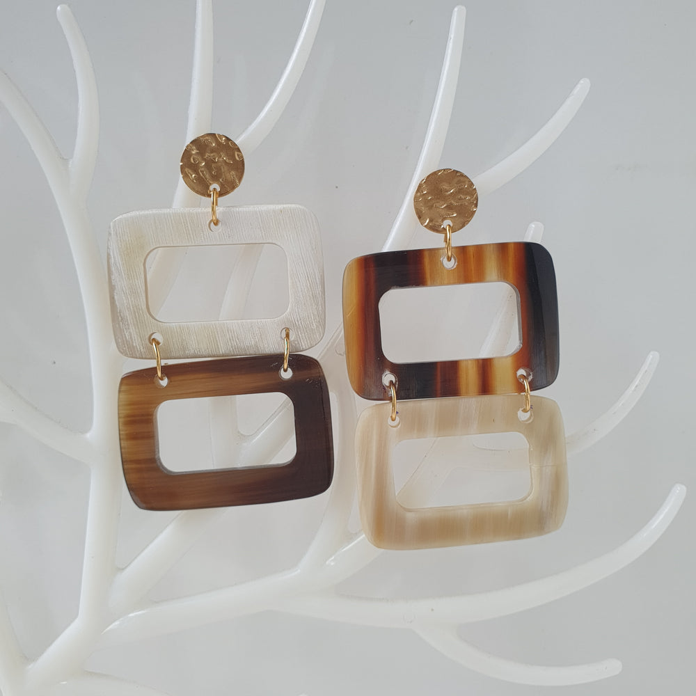 
                  
                    Double rectangle drop earrings are designed by brown and white color with natural buffalo horn on white faux branches
                  
                