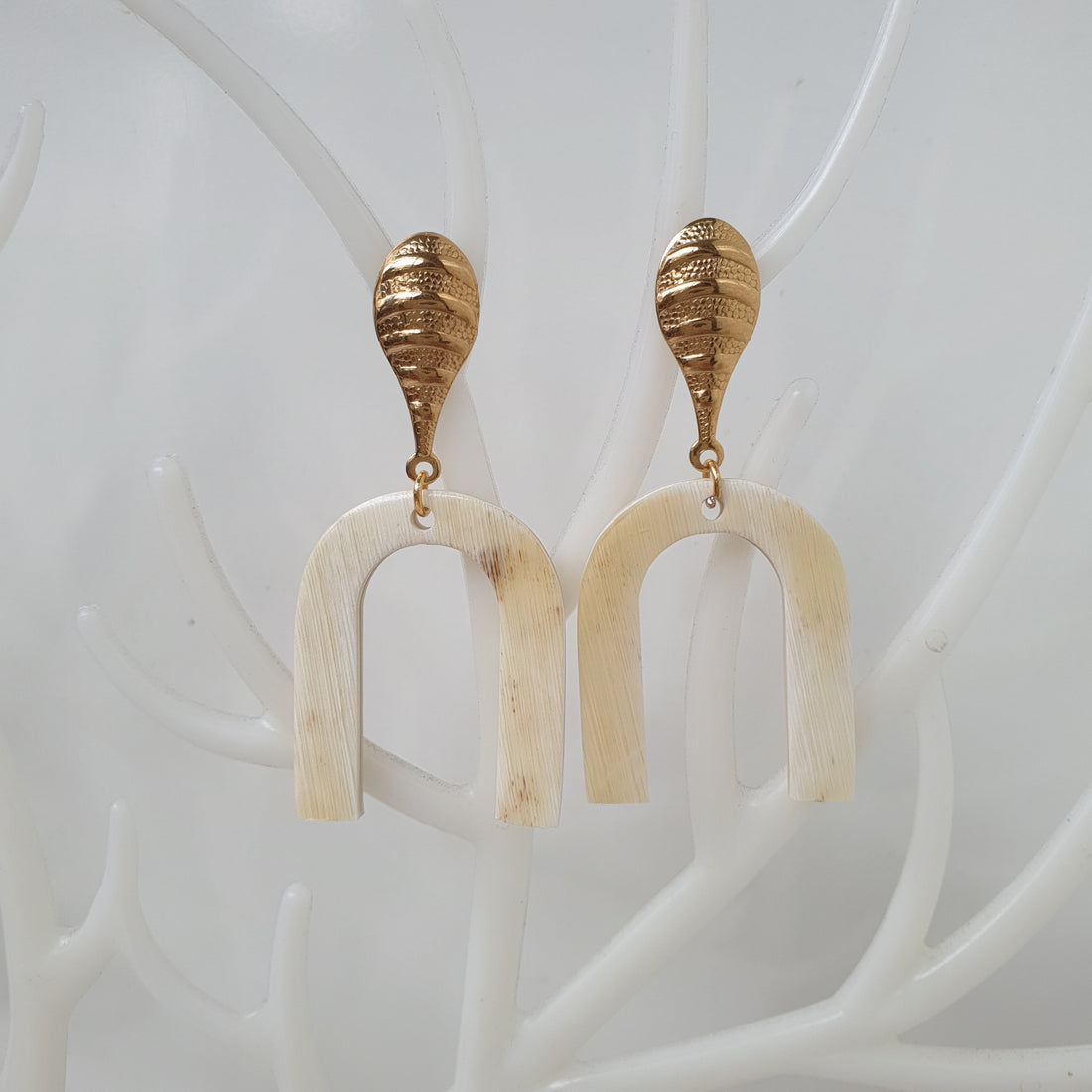 Gold luxury drop earrings are handmade with "H" shape and white color on white faux branches