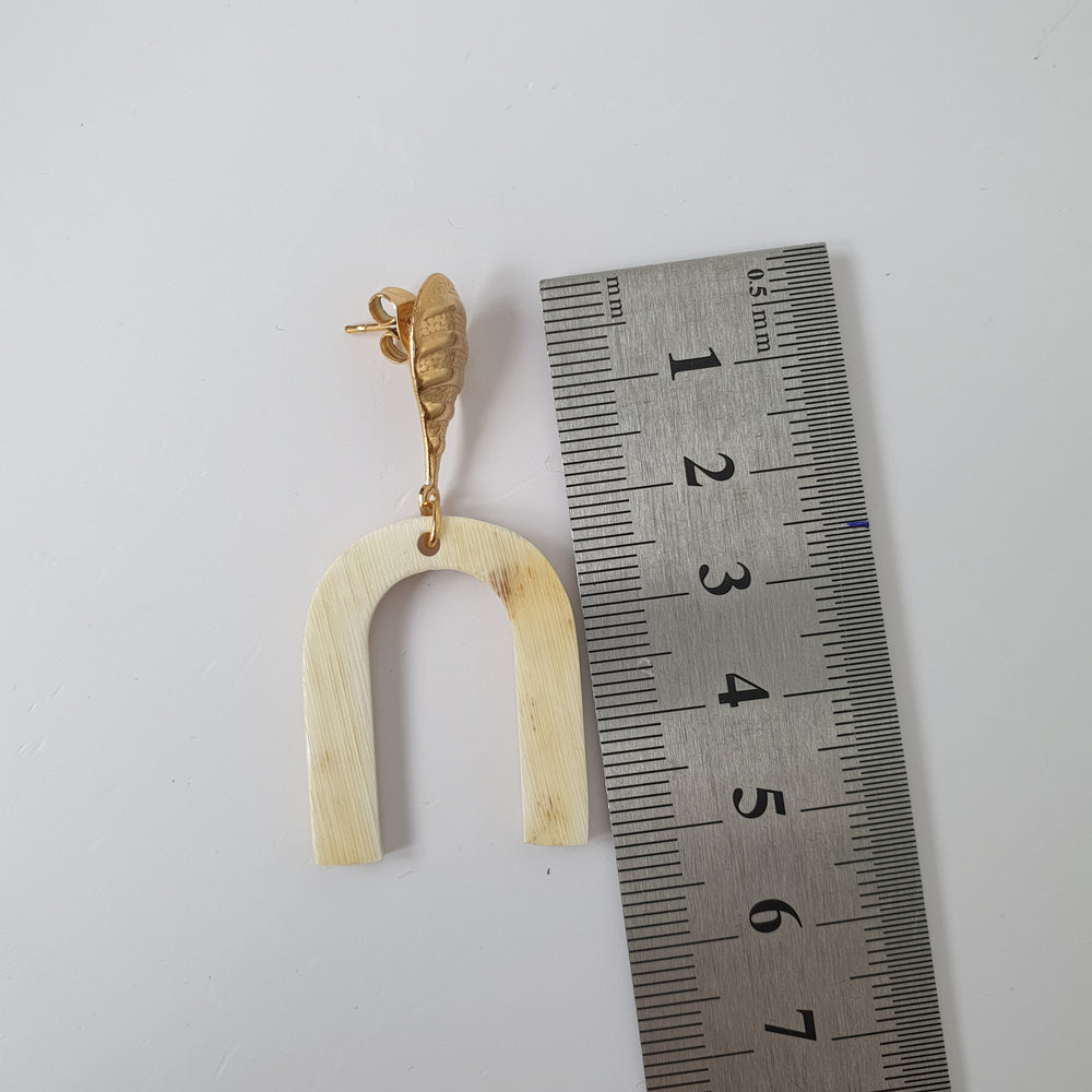 
                  
                    A handmade earring is measured by a ruler on a white background
                  
                