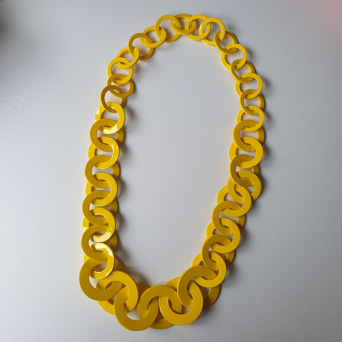 Yellow wide chain necklace features a soild color and nautral buffalo horn on a light background