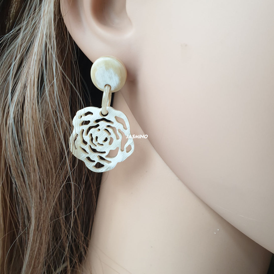 Minimalist white floral drop earrings on a mannequin
