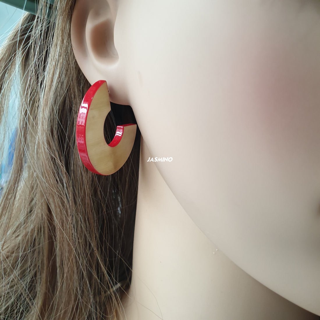 handmade C shaped stud earrings feature scarlet red in natural buffalo horn for Spring 2023 on a mannequin