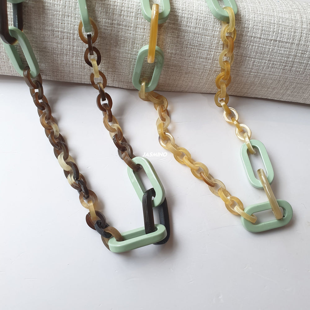 
                  
                    Two cadet blue rectangular chain link necklaces in natural buffalo horn for Spring 2023
                  
                