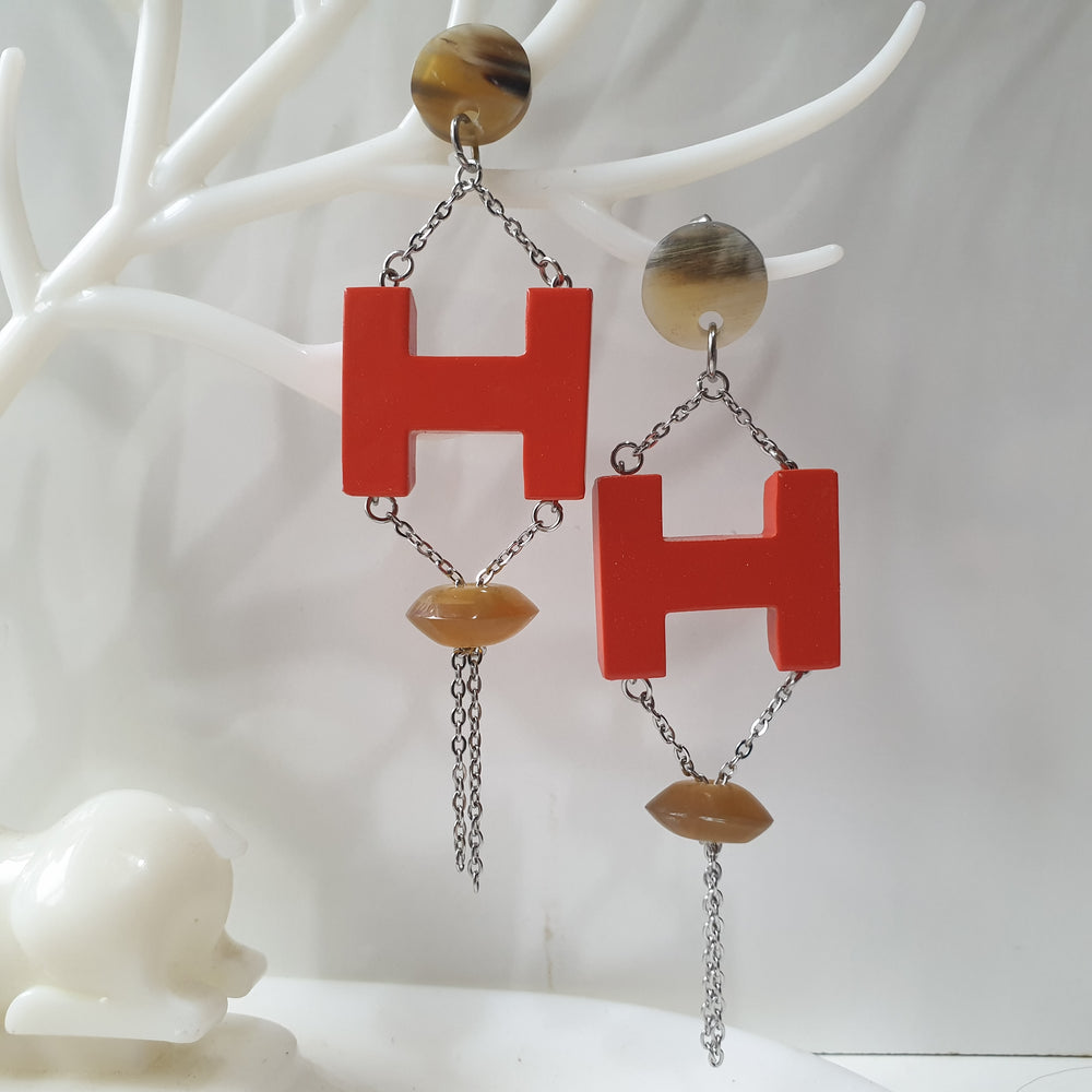 
                  
                    Handmade H-shaped earrings feature orange red in natural buffalo horn for Spring 2023
                  
                