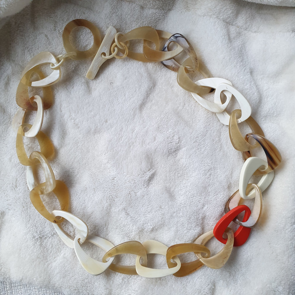 
                  
                    handmade chain link necklace features brown, red, and white in natural buffalo horn for Spring 2023
                  
                