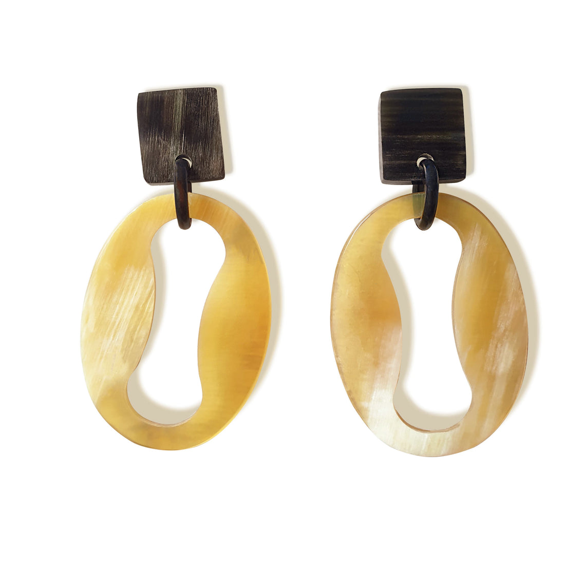 Handmade drop earrings are shaped by a mix of an oval and an infinity symbol featured light colors in the natural light