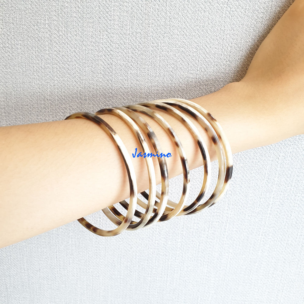 
                  
                    set of seven circle dark buffalo horn bracelets on a dark background, an impressive gift for her
                  
                