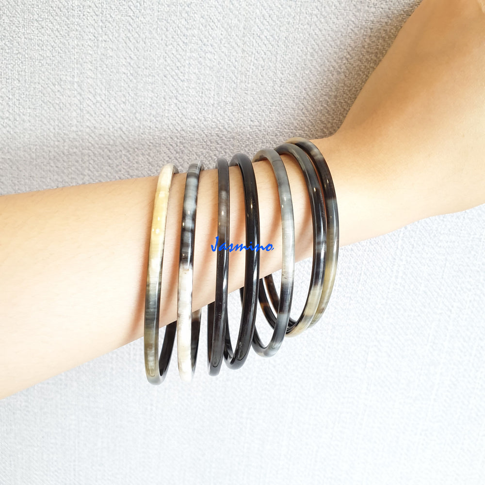 
                  
                    set of seven circle dark buffalo horn bracelets on a dark background, an impressive gift for her
                  
                