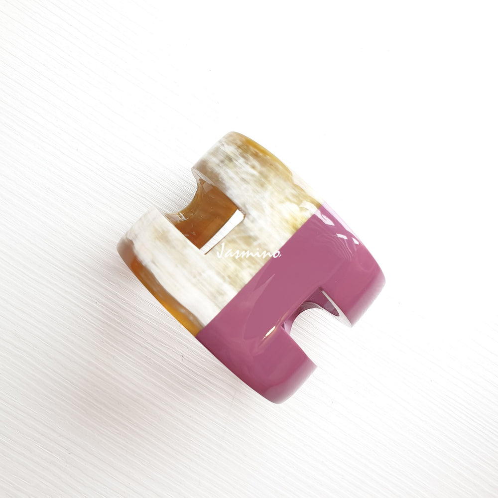 
                  
                    A cuff bracelet is designed by a pink and brown color and made by natural buffalo horn
                  
                