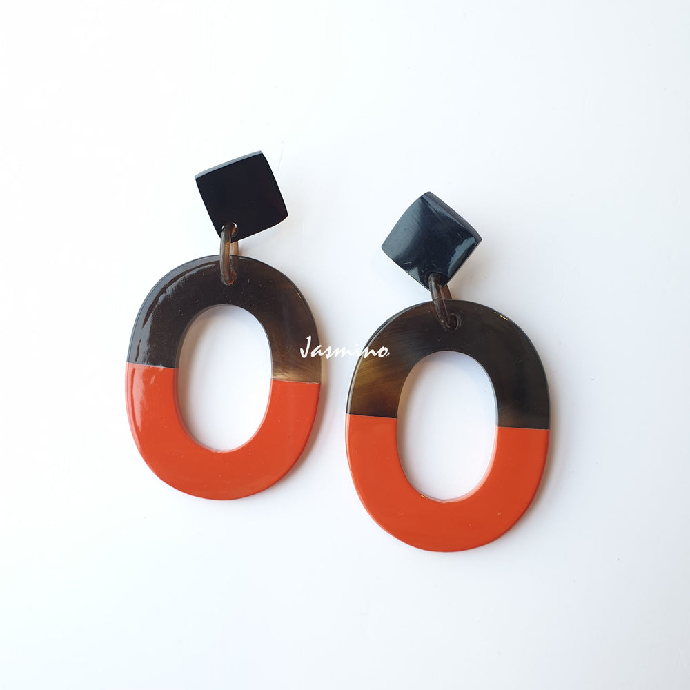 
                  
                    Handmade oval earrings are covered by a brown and burnt orange for a unique gift on a white background for Christmas
                  
                
