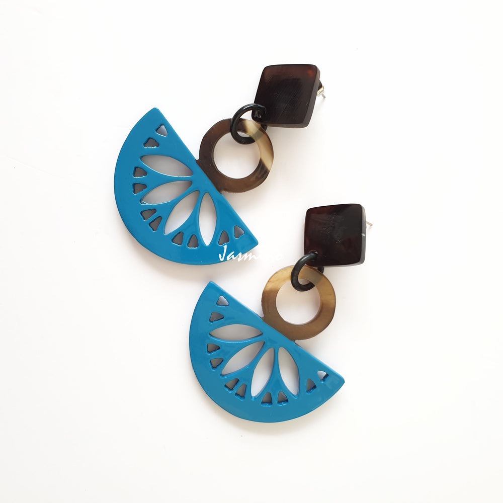 
                  
                    Handmade drop earrings are detailed by Kiwi fruit shape with deep turquoise color and natural buffalo horn material in the natural light
                  
                