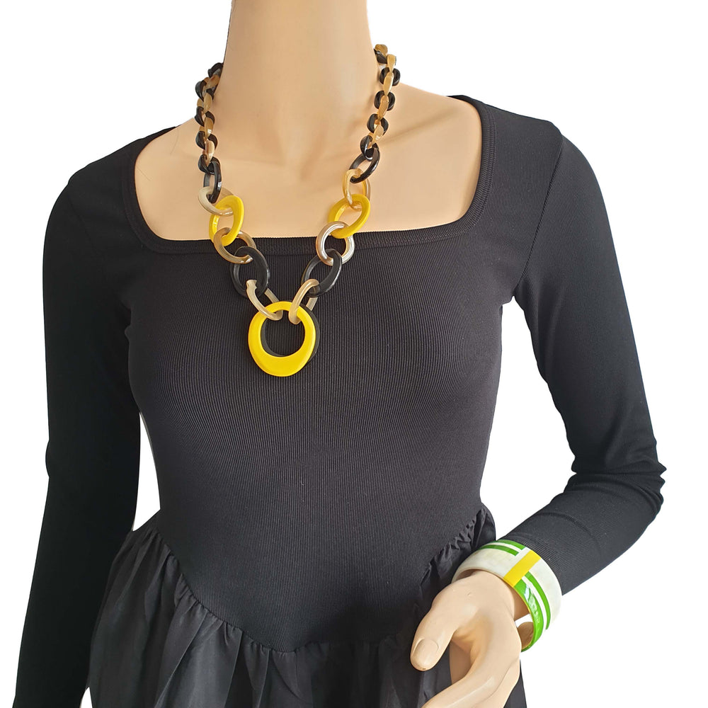 
                  
                    Bright horn jewelry cuff bracelet features white, green, and yellow on wrist
                  
                