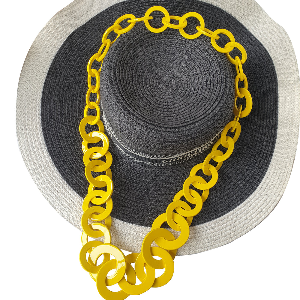 
                  
                     Yellow natural buffalo horn wide chain necklace for women on a black and white broadbrim
                  
                