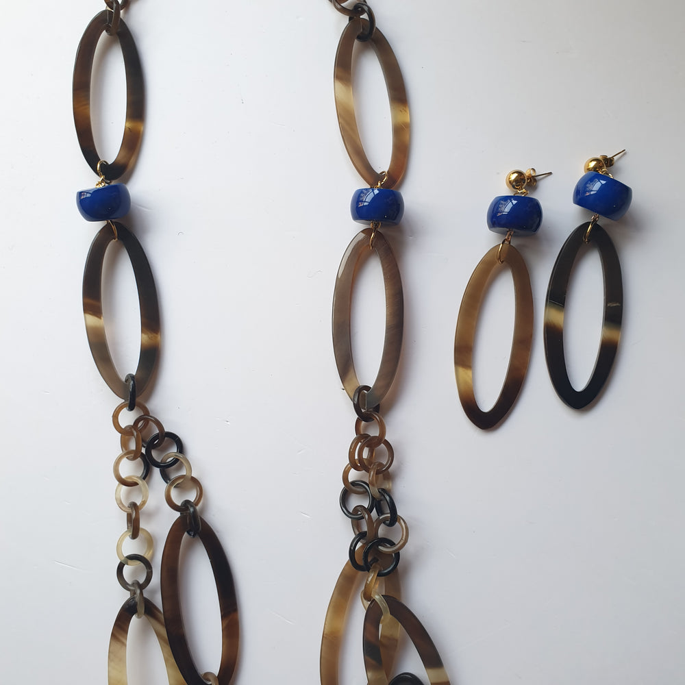 
                  
                    A set of Jasmino Bohemian Girly Oval 18k Gold Plated Brass Jewelry Earrings And Chain Link Necklace In Natural Buffalo Horn In The Natural Light
                  
                