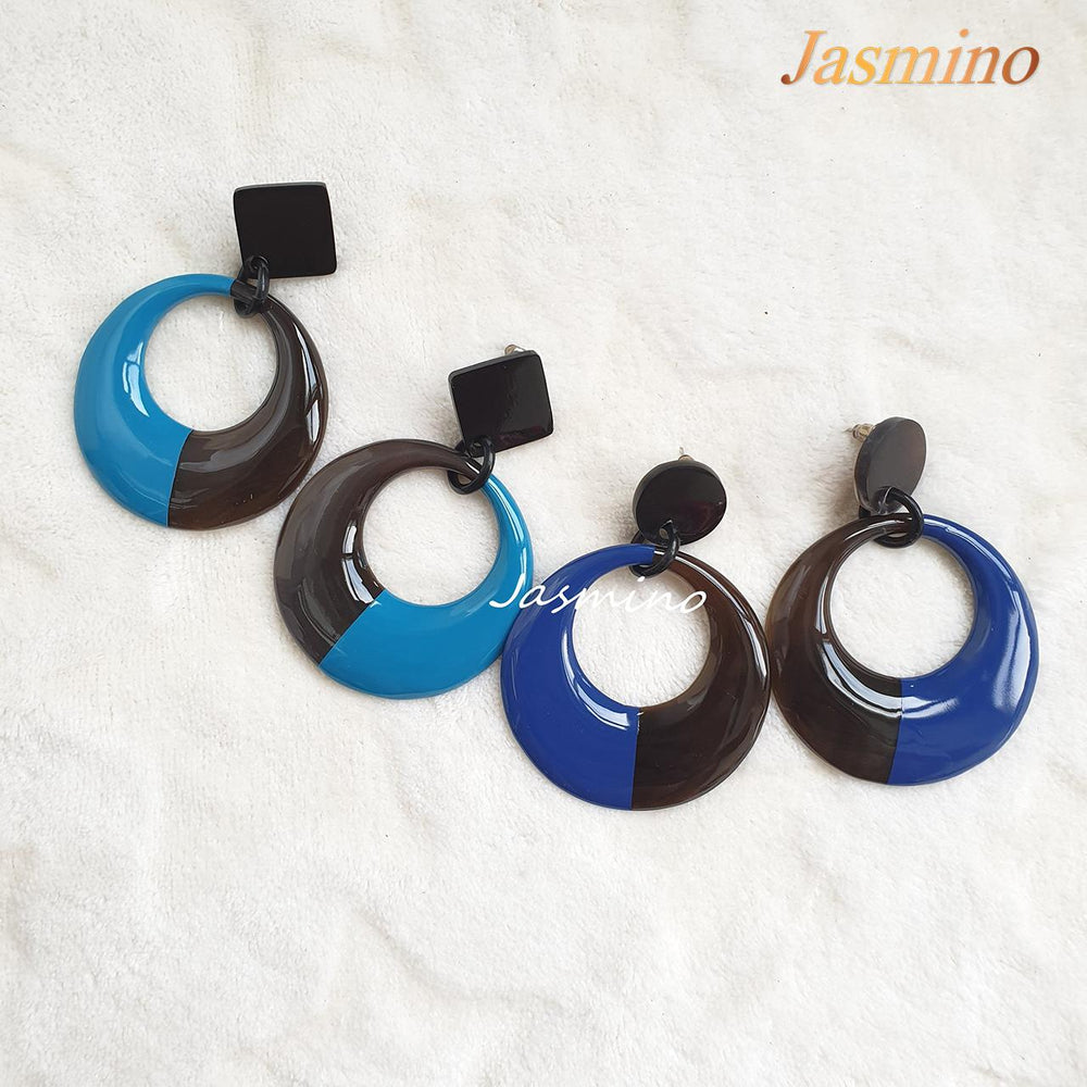 
                  
                    Two pairs of handmade circular earrings are made of natural buffalo horn featured blue color in the natural light
                  
                