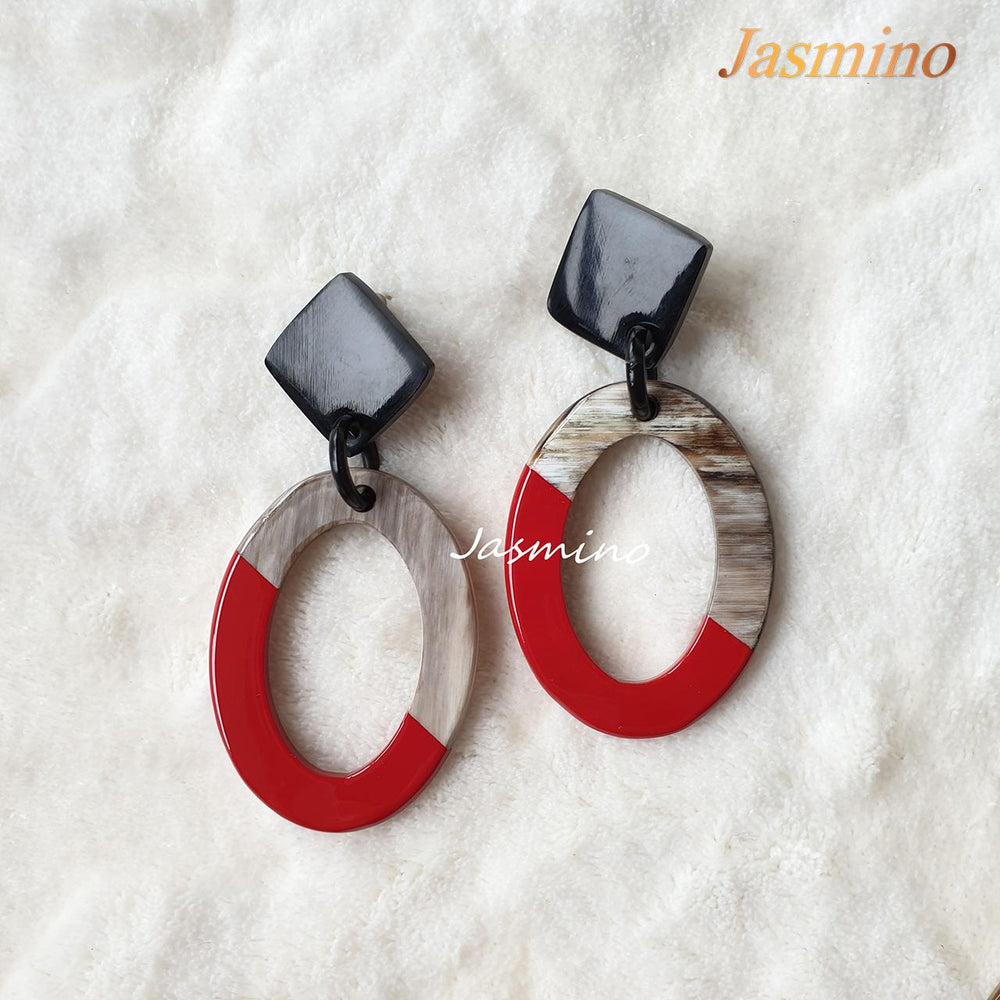 
                  
                    Handmade oval earrings feature a red half and grey half with natural material horn on a white background
                  
                