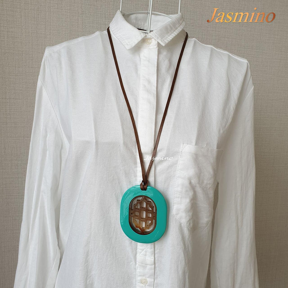 
                  
                    elliptical turquoise lacquer horn pendant with a unique pattern in natural light, impressive gift for her
                  
                